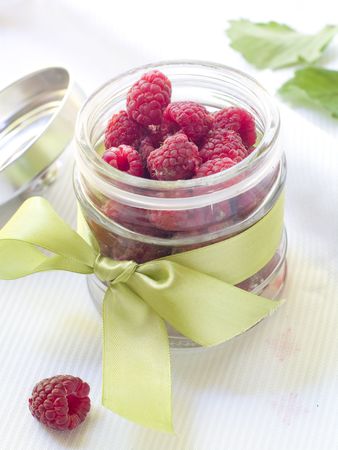 Fresh raspberries in jar with bowの写真素材
