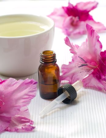 Essential oil bottle with lily in backgroundの写真素材