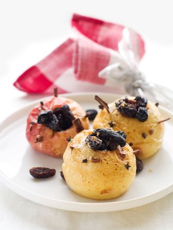 Hot baked apple with cinnam sticks and raisinの写真素材