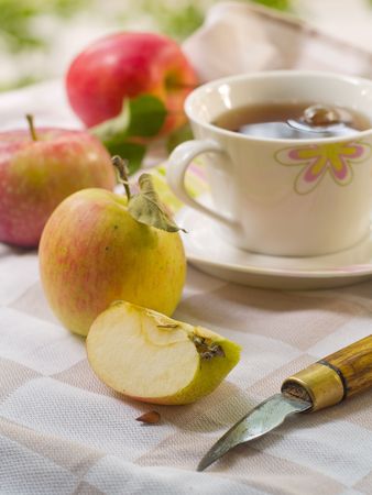 Tea cup on the desk with cutting applesの写真素材