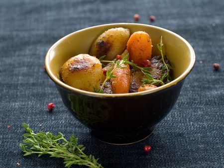 Roasted garlic potatoes and carrots with thyme and pepperの写真素材