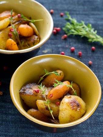 Roasted garlic potatoes and carrots with thyme and pepperの写真素材