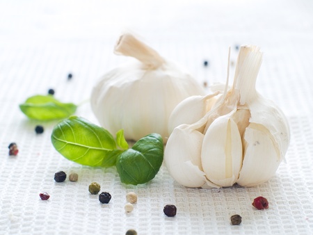 Fresh garlic with pepper and basil  on kitchen towelの写真素材