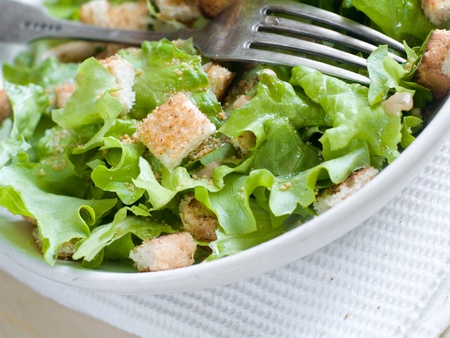 A bowl of fresh lettuce salad with croutonの写真素材