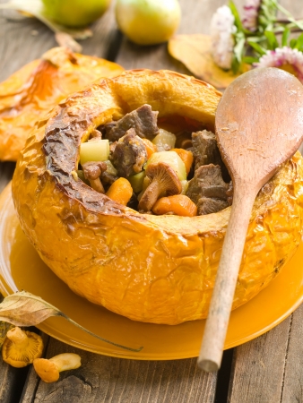 vegetable stew with meat in pumpkin on autumn decoration, selective focusの写真素材