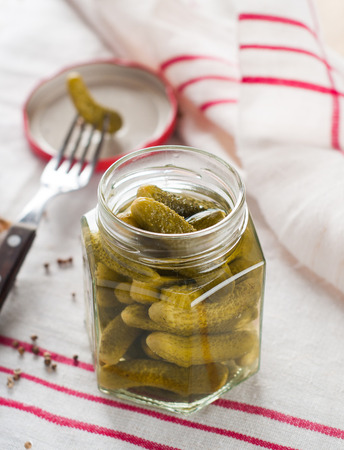 Preserved salted or marinated cucumber in glass jar, selective focusの写真素材