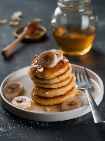Stack of cottage cheese pancakes with honey and banana, selective focusの写真素材