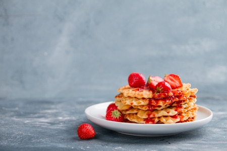 Plate of waffles with strawberry  sauce and fresh berries, selective focusの写真素材
