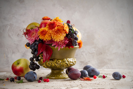 Vase with autumn flowers and fruit, selective focusの写真素材