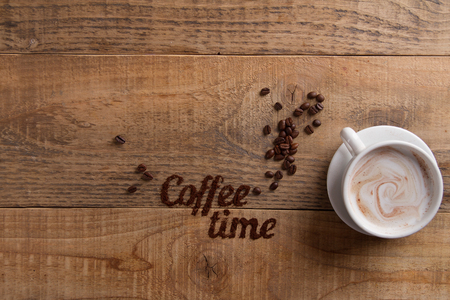 Coffee composition with cup and donut on wooden background, selective focusの写真素材