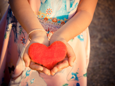 love concept. holding a red heart in hands.の写真素材
