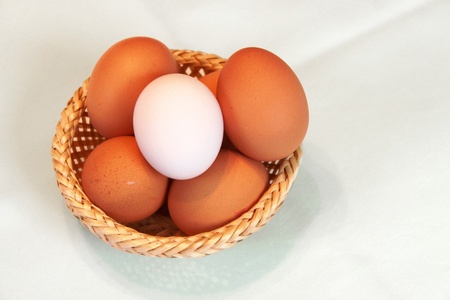 Basket with several eggs is standing on the table.の写真素材