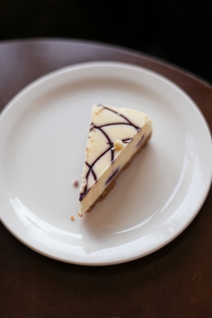 A piece of white vanilla cheesecake on a plate の写真素材