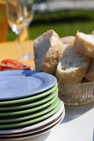 Picture of several plates and some white bread on the table outside の写真素材