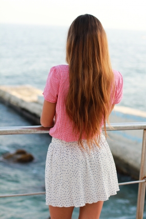 Picture of a young girl looking at the seaの写真素材