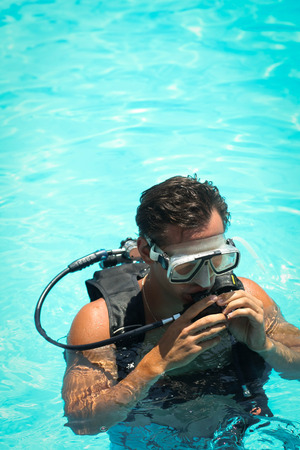 Picture of a young man in a snorkelling mask in a swimming poolの写真素材