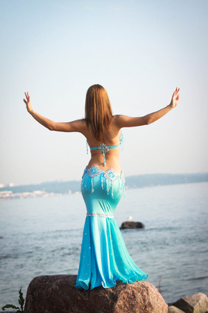 Beautiful lady in eastern costume on the sea shoreの写真素材