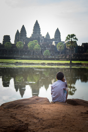 Picture of a little boy looking at Angkor Wat temple in Cambodiaの写真素材