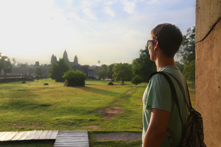Picture of a tourist looking at Angkor Wat temple in Cambodiaの写真素材