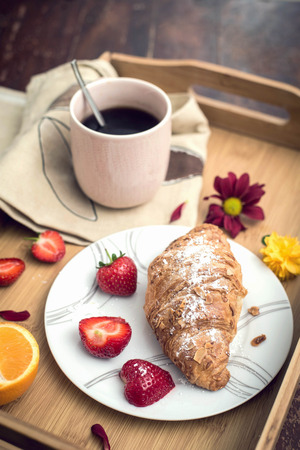 Coffee, croissant and fruits on the trayの写真素材