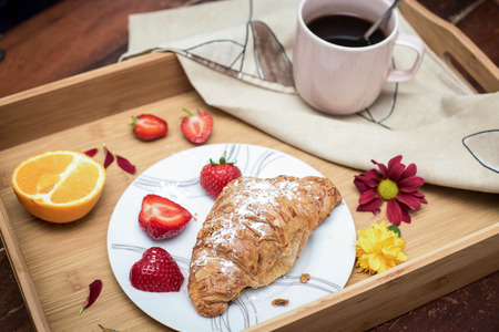 Coffee, croissant and fruits on the trayの写真素材