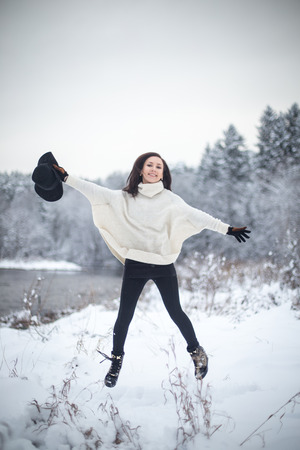 Young woman jumping in the snowの写真素材
