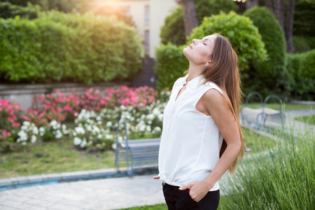 Pretty young woman enjoying the sunshine in the parkの写真素材