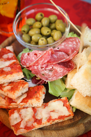 Delicious food platter with salami, bread, pizza and olivesの写真素材