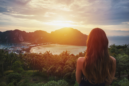 A girl admiring amazing view of Phi Phi island at sunset. View from the back.の写真素材