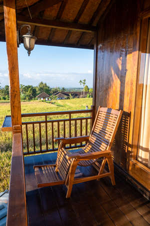 Chair on the balcony in a wooden house with a beautiful viewの写真素材