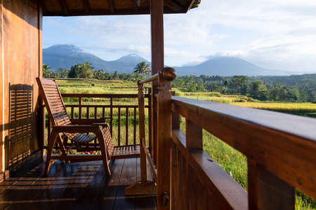 Chair on the balcony in a wooden house with a beautiful viewの写真素材
