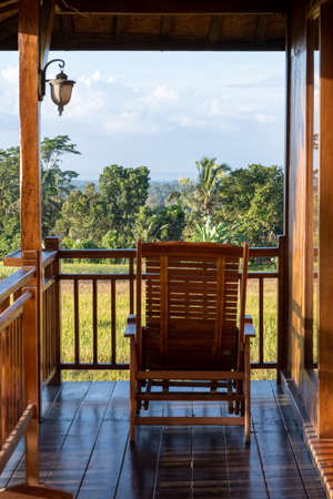 Chair on the balcony in a wooden house with a beautiful viewの写真素材