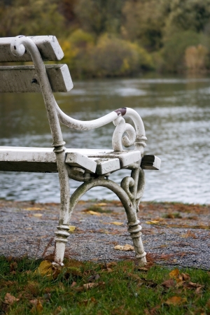Detail of the old white bench in the park by the river の写真素材