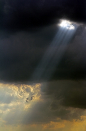 Ray of sunlight through the black clouds before the storm.の写真素材