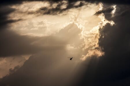 Small helicopter against big cloudy sky.の写真素材