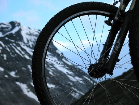 sky and mountain through a bicycle wheelの写真素材
