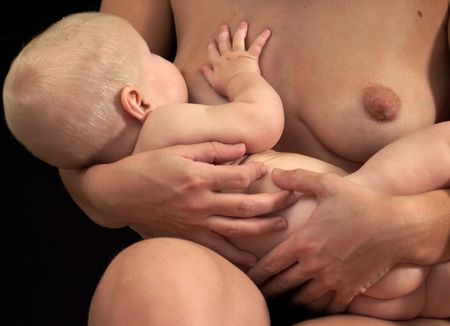 breastfeeding baby girl, both  on black backgroundの写真素材