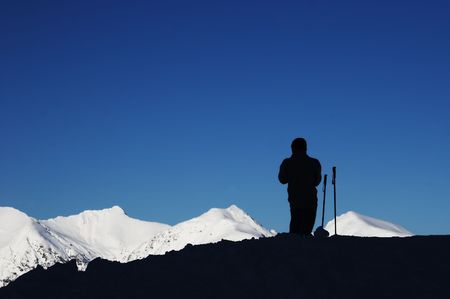 black silhouette of skier, blue sky and white mountainの写真素材
