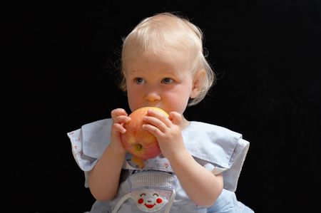 little blonde girl with big apple in handsの写真素材