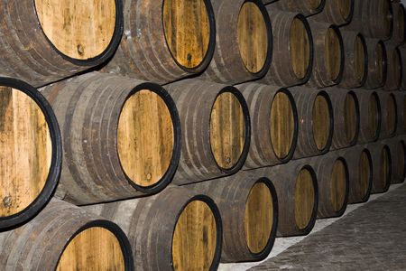 rows of tuns in wine cellar, closeup