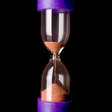 hourglass with falling sand isolated on blackの写真素材