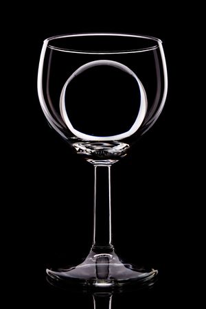 wineglass silhouette with transparent ball inside, isolated on blackの写真素材