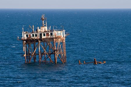 rusty tower of sunk ship prominent above sea surfaceの写真素材