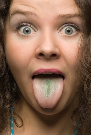 funny woman with green tongue close-up portraitの写真素材