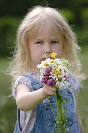 little girl with bunch of flowers in handsの写真素材