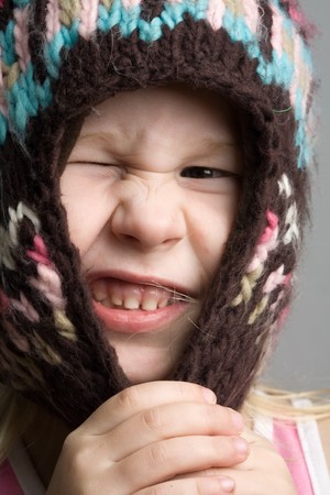 closeup funny portrait of little girl in winter hat