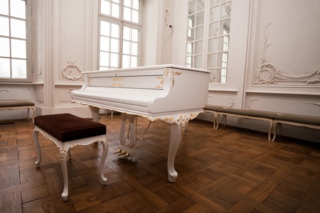 white grand piano standing in elegant white interior of  palace hallの写真素材