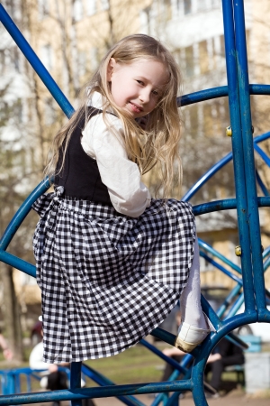 fair-haired pretty little girl playing on outdoor playgroundの写真素材