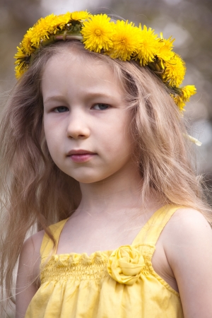 portrait of little fair-haired girl in dandelion wreathの写真素材