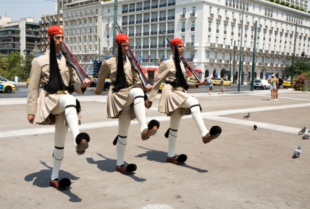 three soldiers from guard of honour marching in traditional military uniform before Greek parliament in Athensのeditorial素材